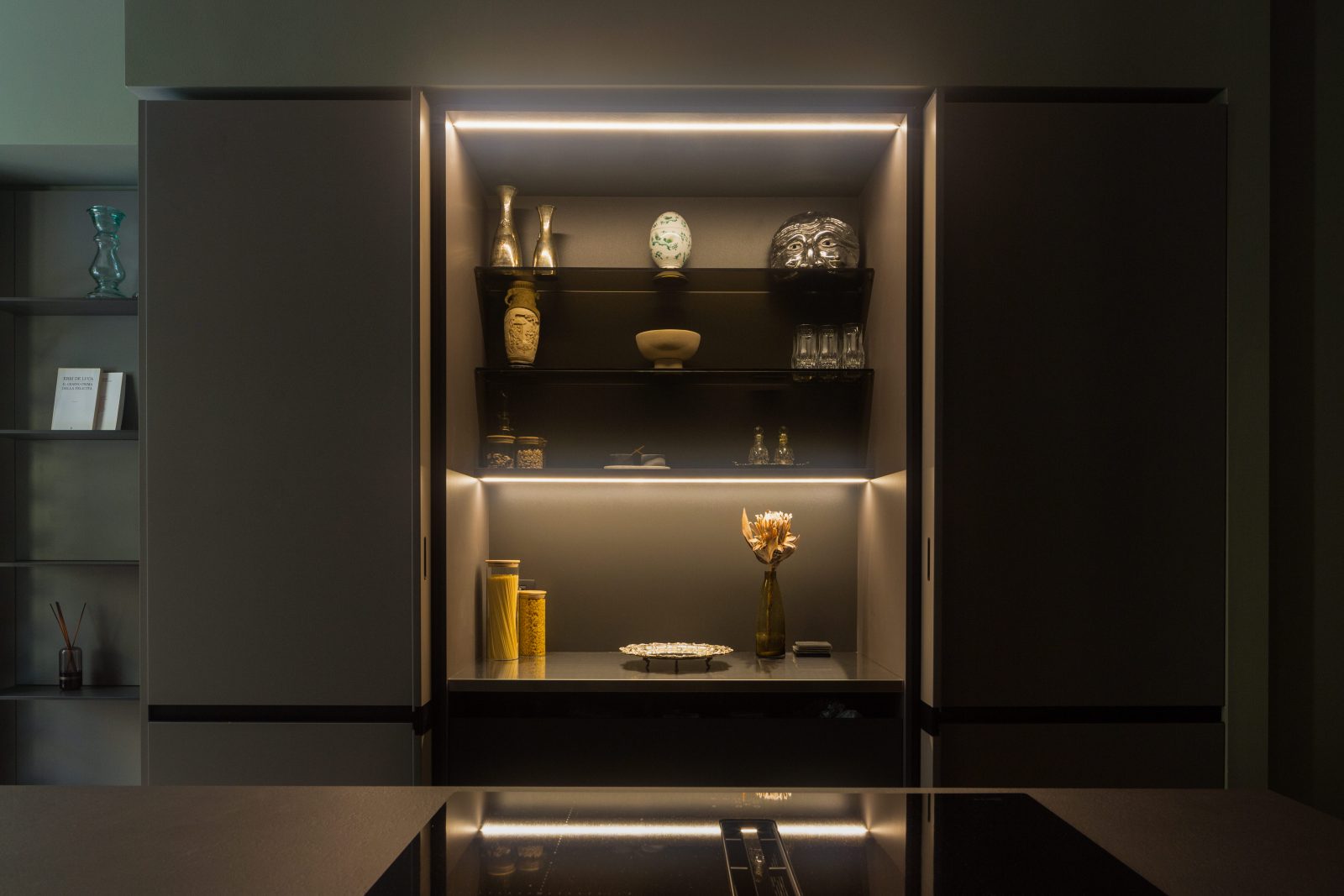 archventil_interior_design_milano_appartamento_residenziale_santa_lucia_78_zona_living_cucina_scura_colonne_rientranti_piano_penisola_terrazzo_veranda_funzionalità